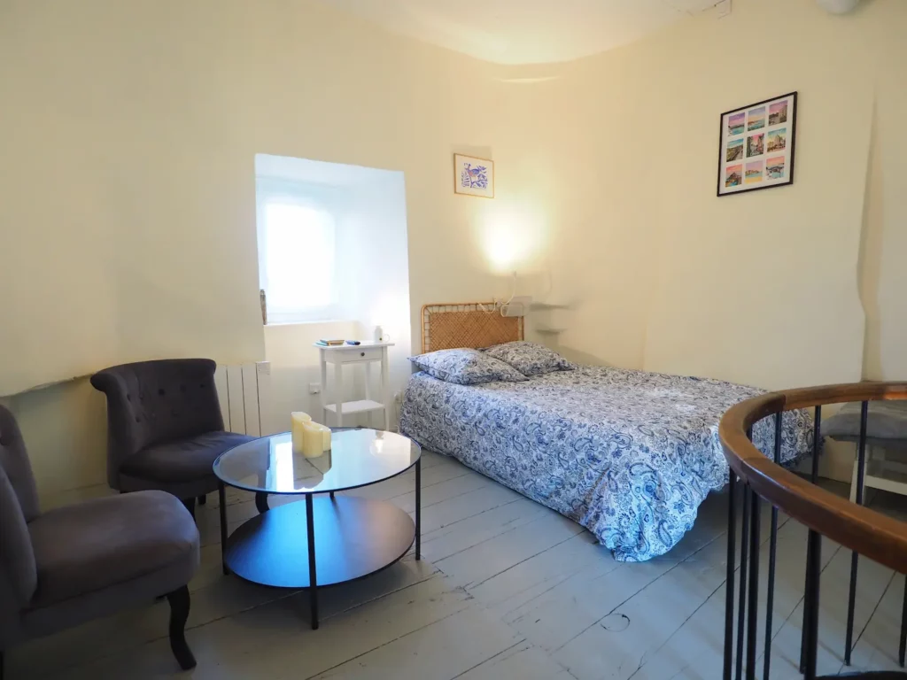 La chambre avec un petit salon et sa table basse.