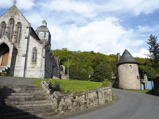 La tour médiévale apparait à quelques mètres de l'église et au pied de la forêt.