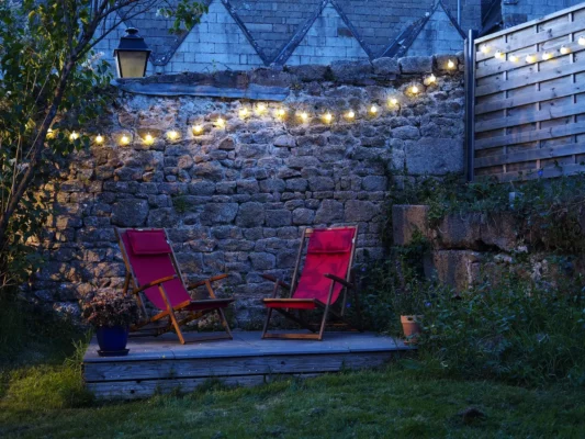 deux chaises longues sur la terrasse à la tombée du jour.